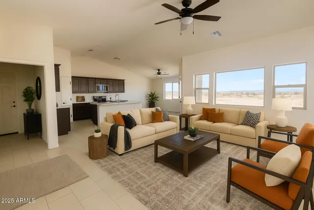 a living room with furniture kitchen view and a large window