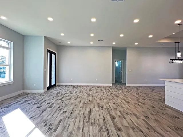 a view of empty room with window and ceiling fan