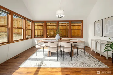 a view of a dining room with furniture a chandelier and wooden floor