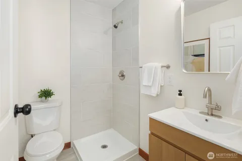 a bathroom with a sink a toilet and shower