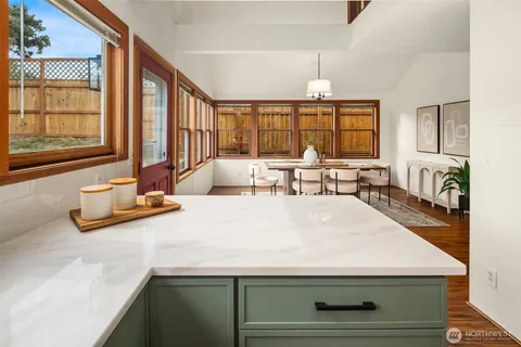 a living room with large window and chandelier