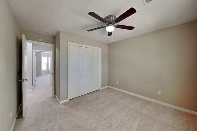 an empty room with closet and a chandelier fan