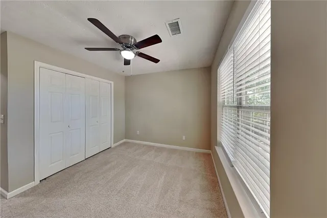a view of a livingroom with a ceiling fan and window