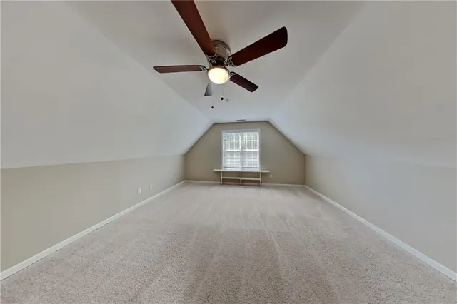 an empty room with ceiling fan and windows