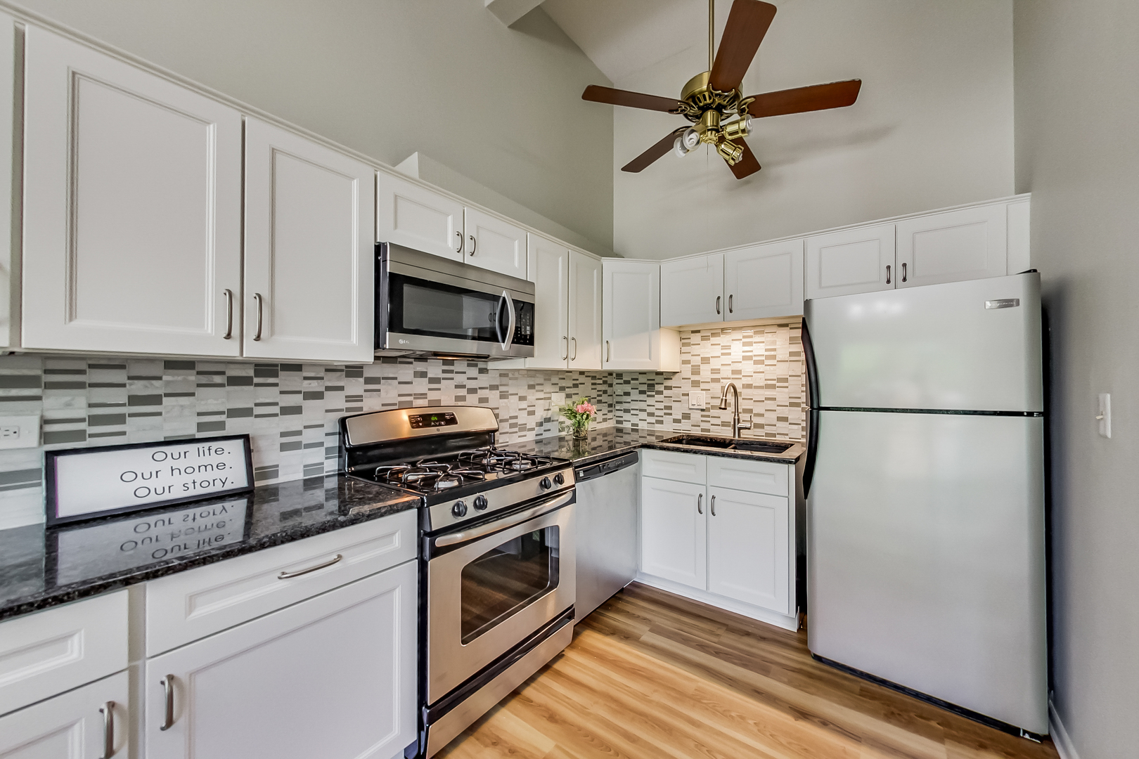 217 Troy Lane Lombard, IL 60148 - Photo 6 of 30 a kitchen with granite countertop a refrigerator a stove a microwave and cabinets