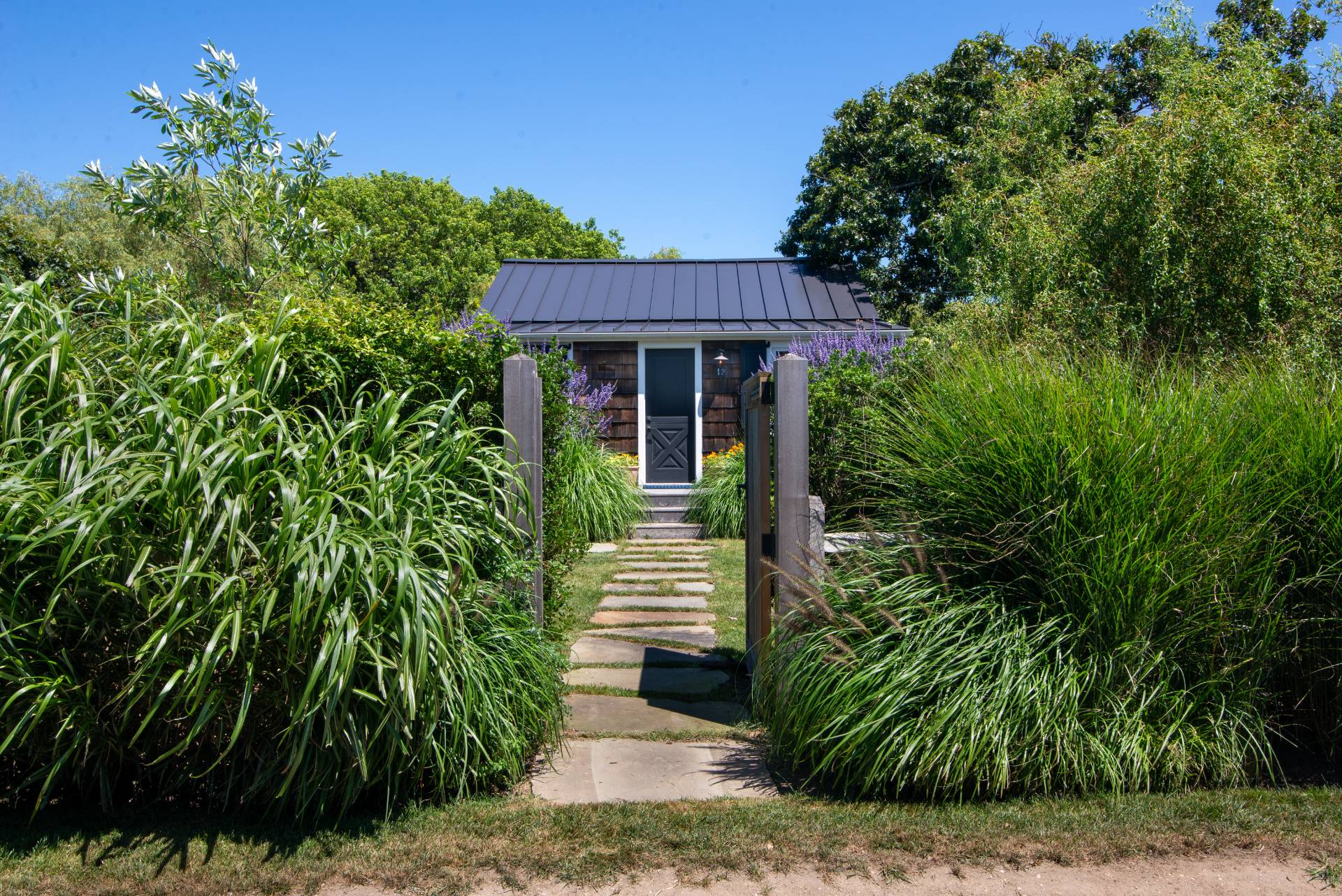 12 Jackson Road Montauk, NY 11954 - Photo 17 of 36 a front view of a house with a garden
