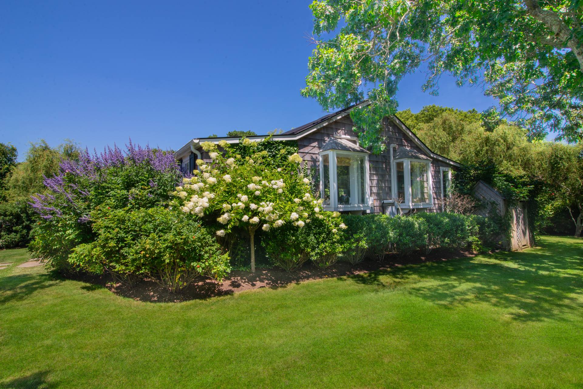 12 Jackson Road Montauk, NY 11954 - Photo 30 of 36 a house that has a big yard and potted plants in front of it
