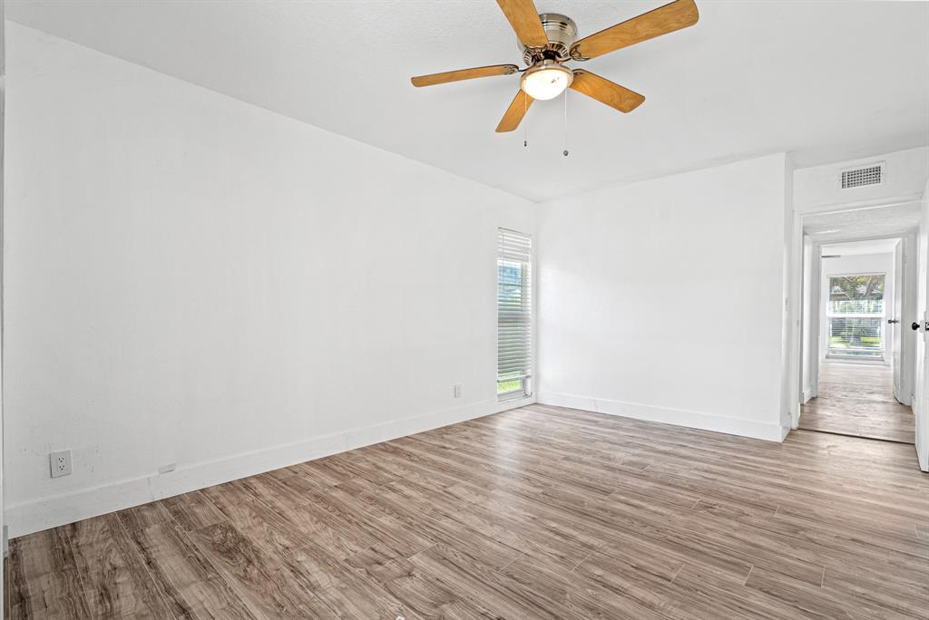 7007 Northwest 64th Street Tamarac, FL 33321 - Photo 23 of 41 an empty room with wooden floor fan and windows