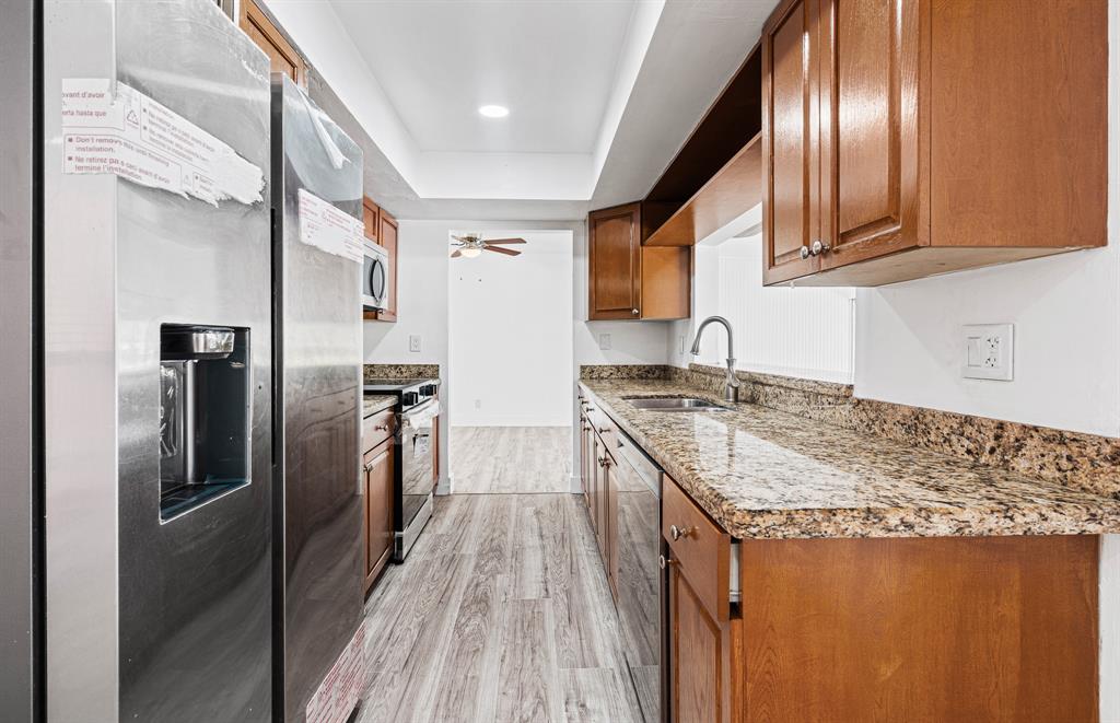 7007 Northwest 64th Street Tamarac, FL 33321 - Photo 32 of 41 a kitchen with granite countertop stainless steel appliances a sink stove and refrigerator