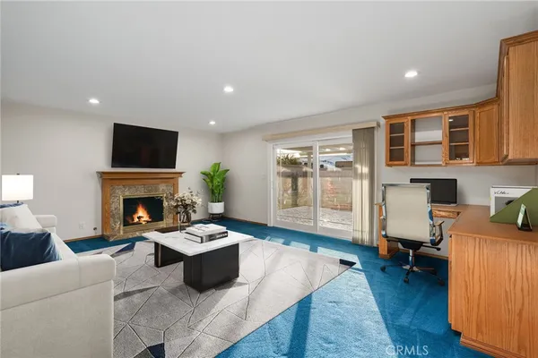 a living room with furniture a rug and a view of kitchen