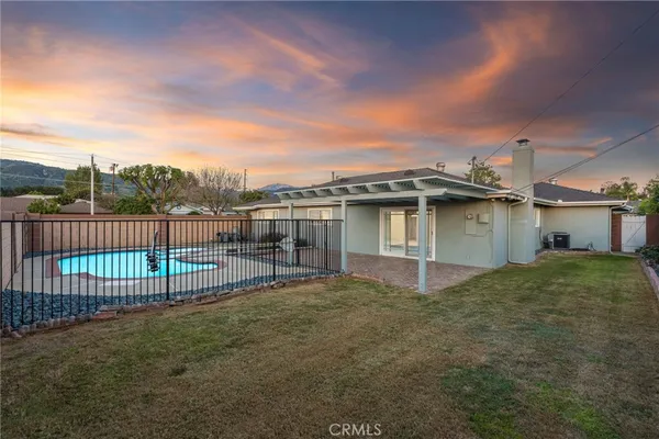 a view of a swimming pool with a patio and a yard
