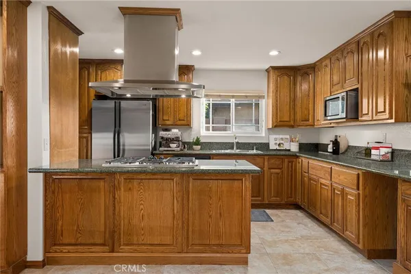 a kitchen with stainless steel appliances granite countertop a sink a stove and a refrigerator