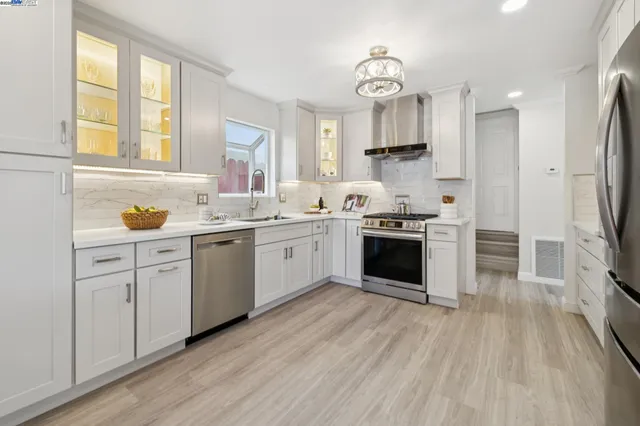 a kitchen with a sink wooden floor and stainless steel appliances