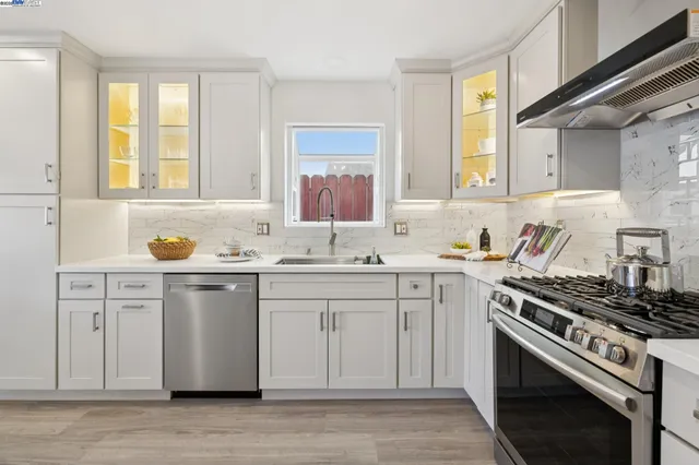 a kitchen with white cabinets and appliances