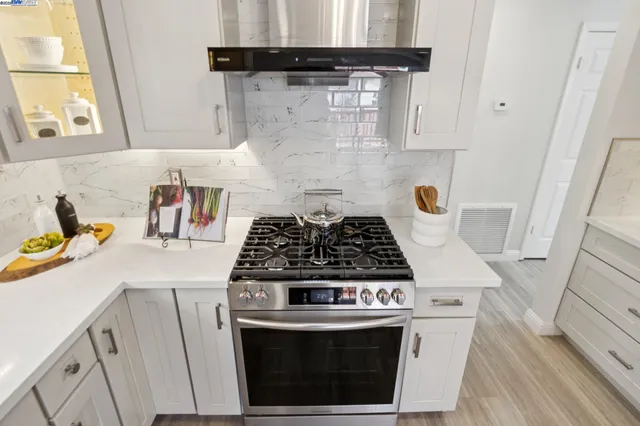 a stove top oven sitting inside of a kitchen