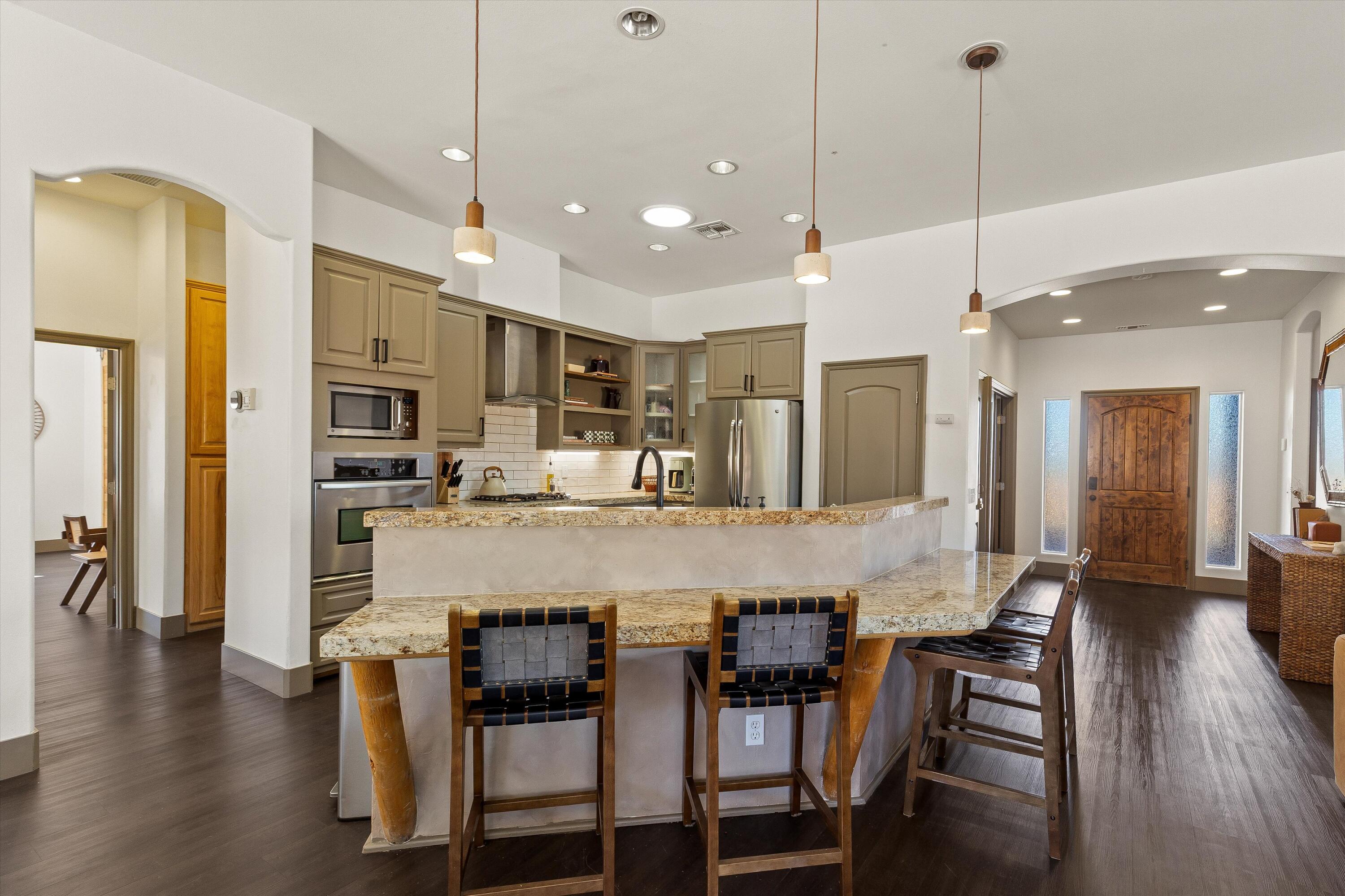 60377 Pueblo Trail Joshua Tree, CA 92252 - Photo 17 of 57 a large kitchen with kitchen island a dining table chairs and wooden floor