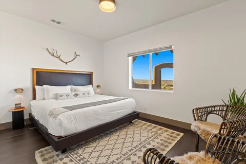 a bedroom with a bed and painting on the wall