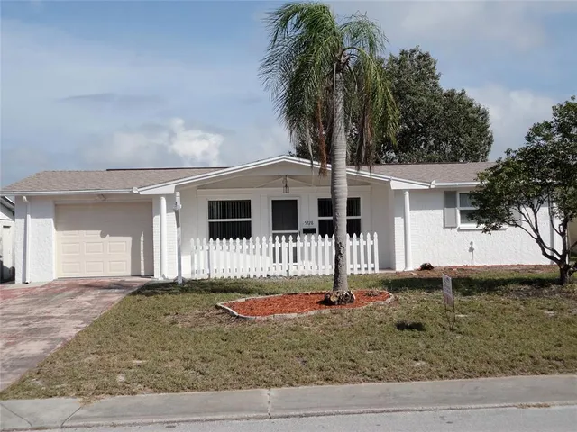 a front view of a house with a yard and potted plants