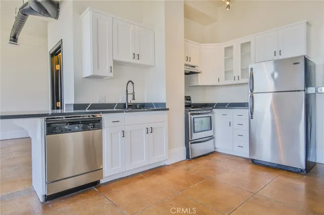 a kitchen with stainless steel appliances granite countertop a refrigerator and a stove