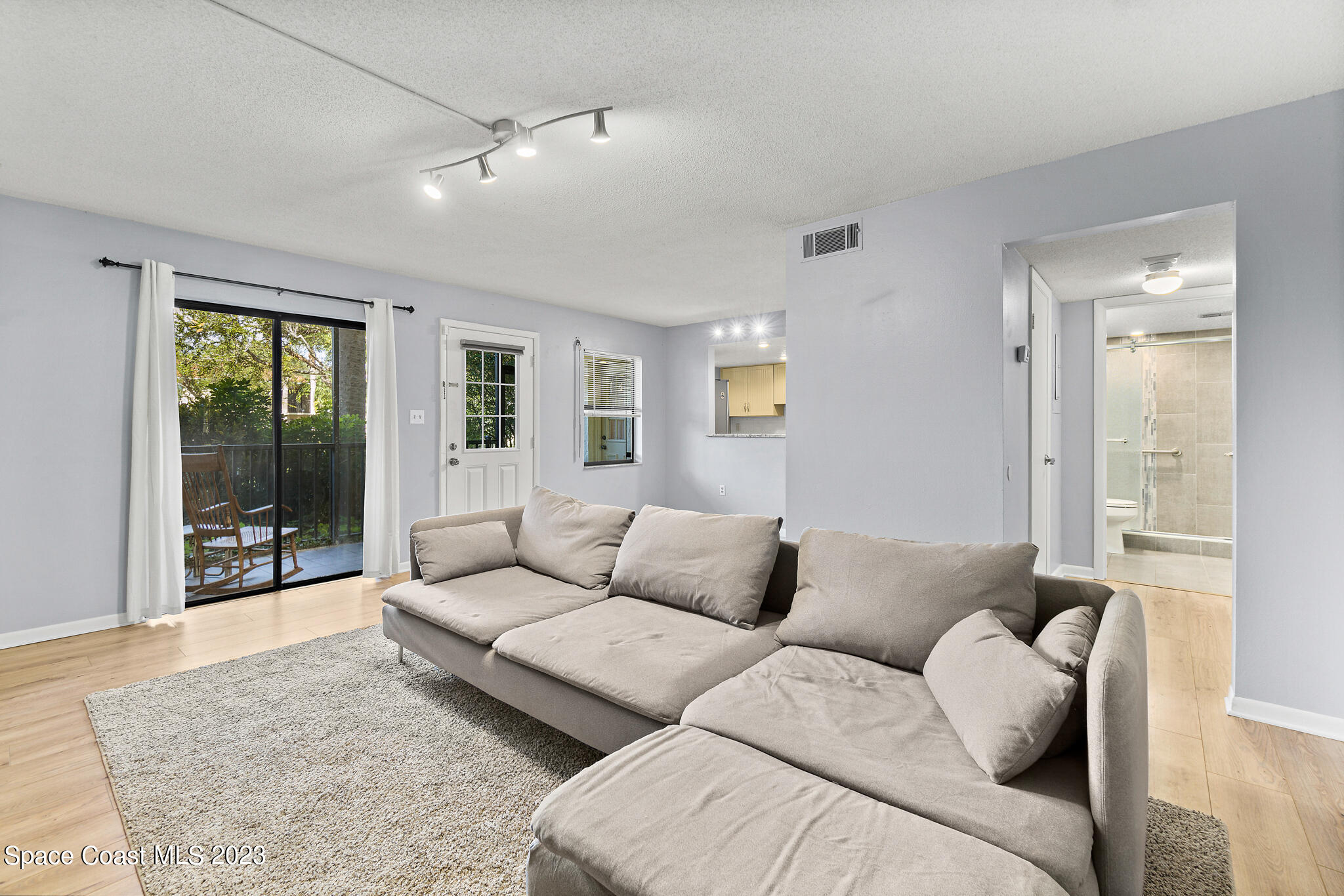 500 Catalina Road, Unit 103 Cocoa Beach, FL 32931 - Photo 5 of 28 a living room with furniture and a large window