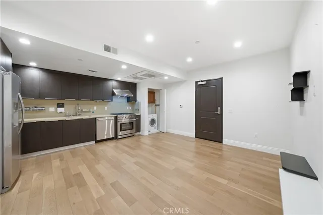 a large white kitchen with a sink and a refrigerator