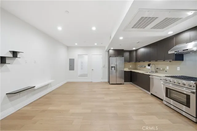 a large white kitchen with a stove top oven a sink and dishwasher
