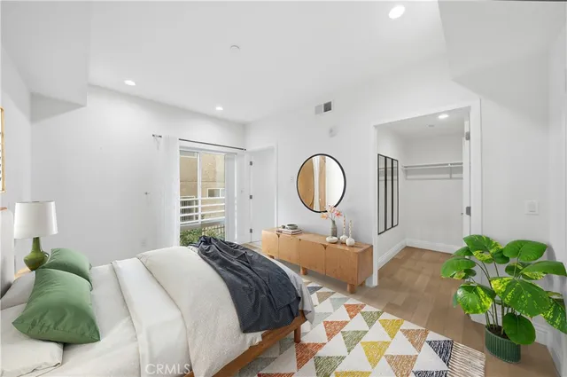 a bedroom with a bed mirror and a potted plant