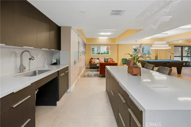 a large kitchen with stainless steel appliances lots of counter space and a sink