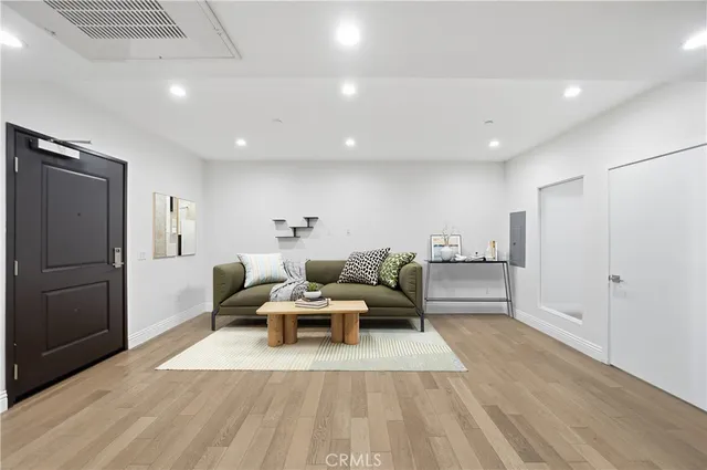 a living room with furniture and a refrigerator