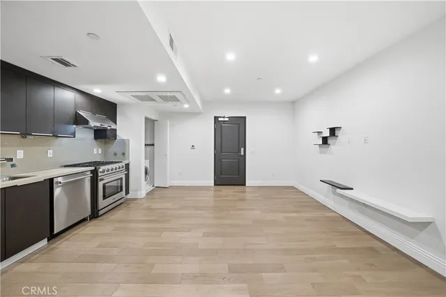a large kitchen with kitchen island a sink stainless steel appliances and cabinets
