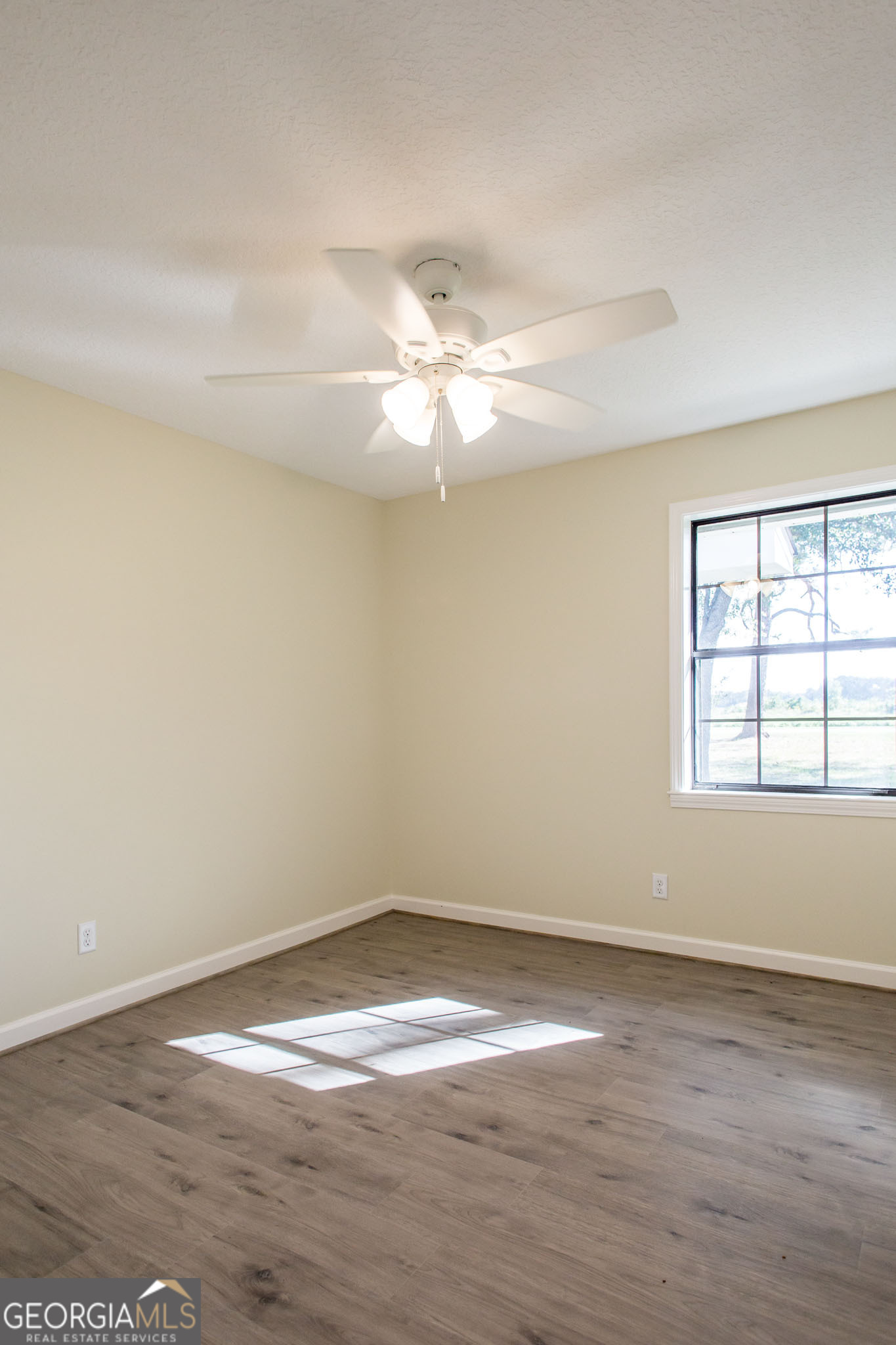 6731 Youmans Chapel Road Blackshear, GA 31516 - Photo 27 of 33 an empty room with wooden floor and fan
