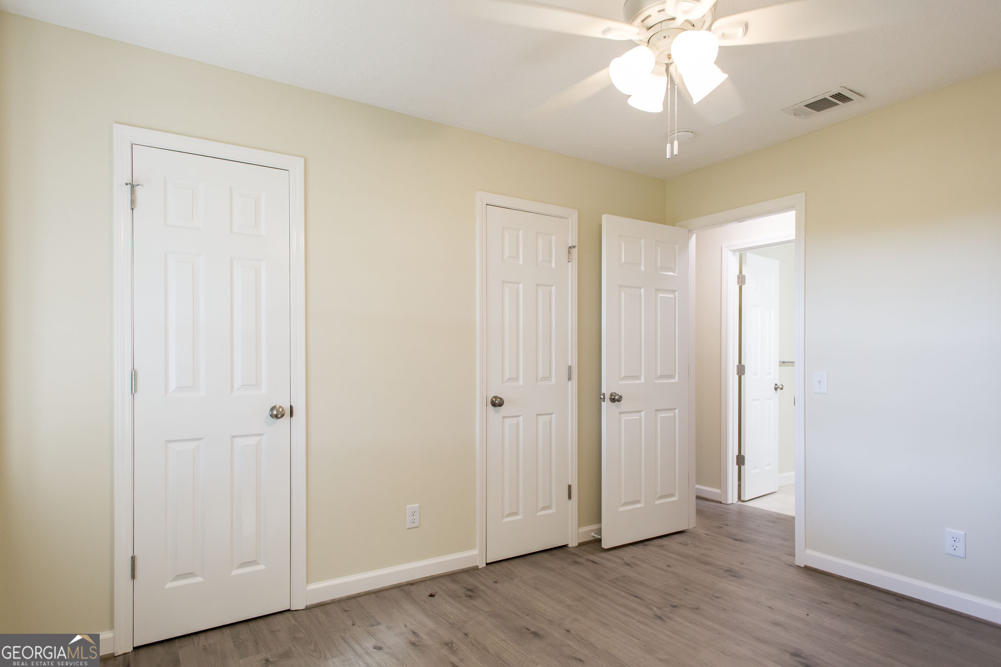 6731 Youmans Chapel Road Blackshear, GA 31516 - Photo 28 of 33 an empty room with wooden floor and fan