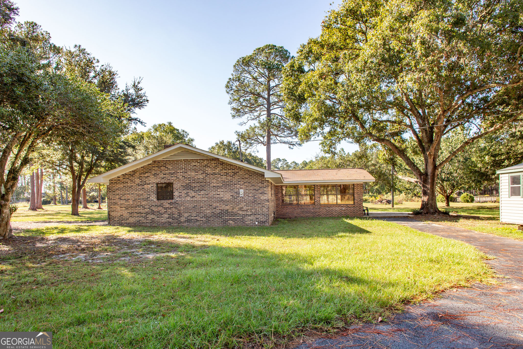 6731 Youmans Chapel Road Blackshear, GA 31516 - Photo 6 of 33 a view of a house with a yard and trees
