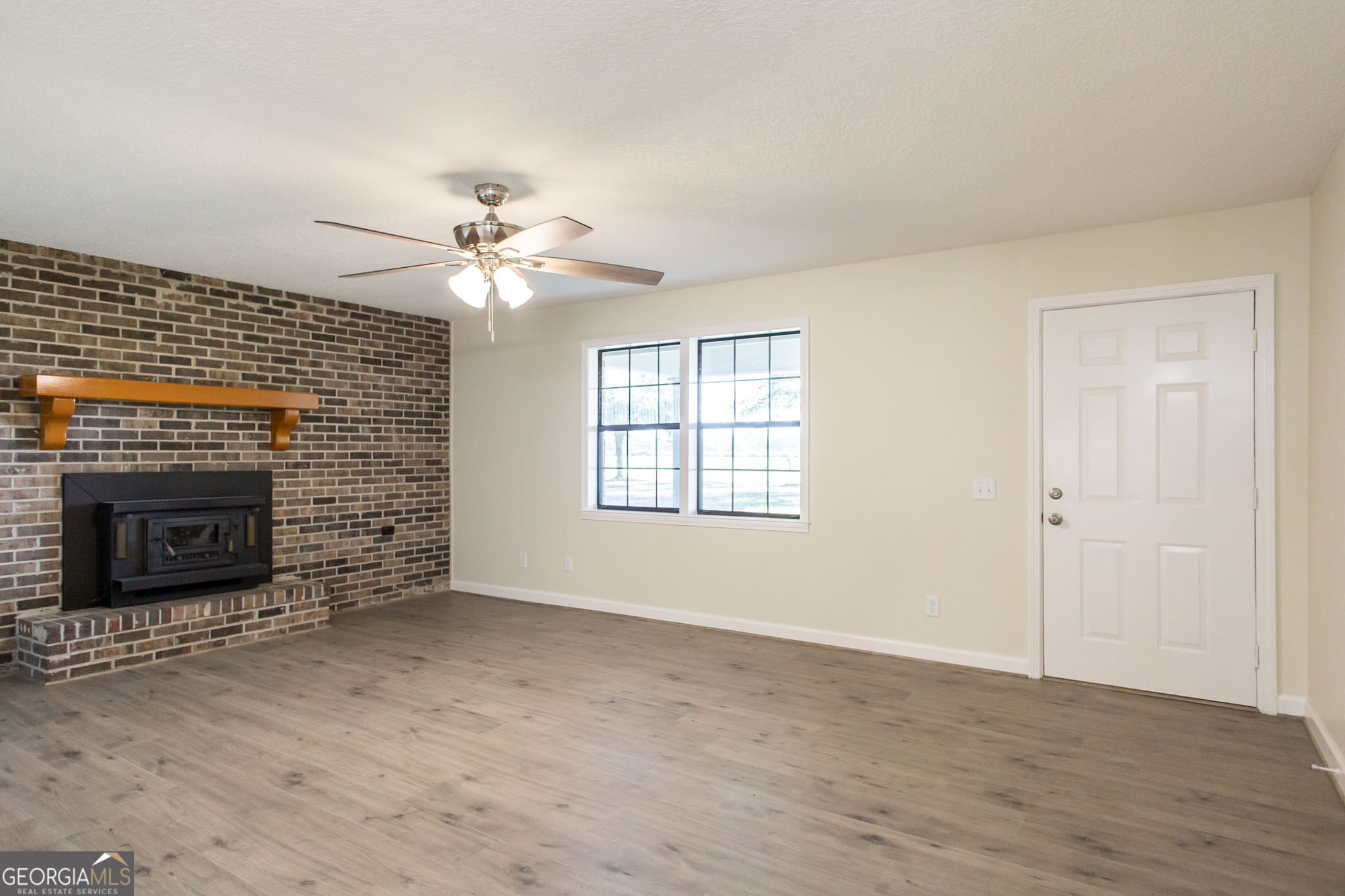 6731 Youmans Chapel Road Blackshear, GA 31516 - Photo 9 of 33 a view of a livingroom with a fireplace and a ceiling fan