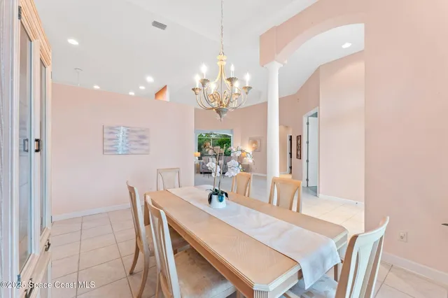 a dining room with wooden floor a chandelier a wooden table and chairs