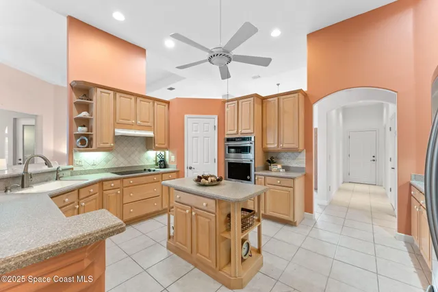 a kitchen with stainless steel appliances granite countertop a stove a sink and a refrigerator