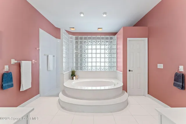 a spacious bathroom with a tub shower and mirror