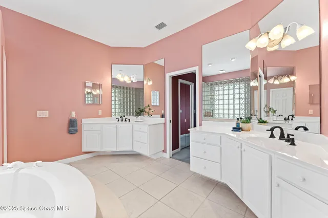 a large white bathroom with a sink a mirror and a bathtub