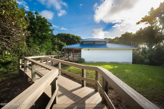 a view of an house with backyard and a tree