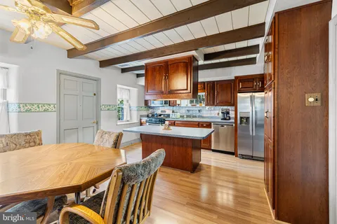 a kitchen with granite countertop wooden cabinets stainless steel appliances and a counter space