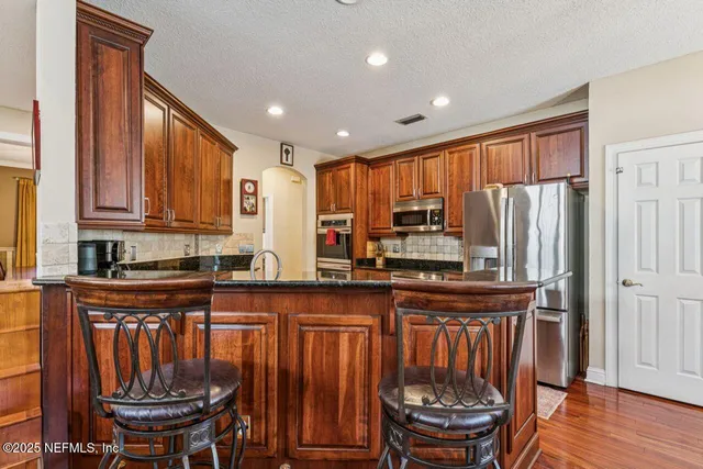 a dining room with furniture a chandelier and wooden floor