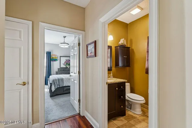 a bathroom with a granite countertop toilet sink and mirror