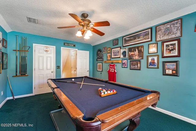 a room with chandelier fan and windows
