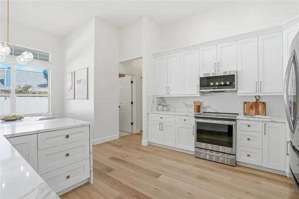 a kitchen with white cabinets and stainless steel appliances