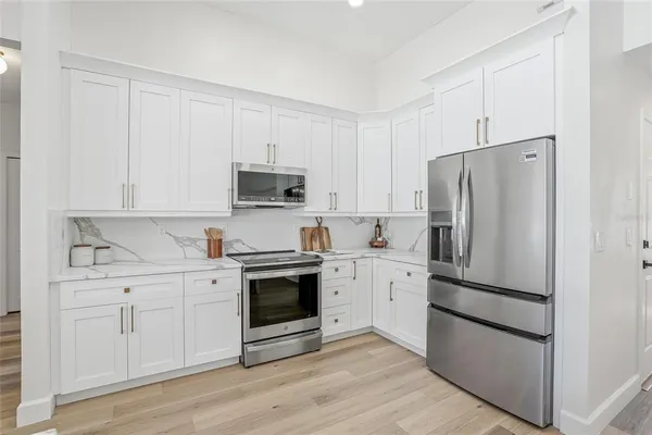 a kitchen with cabinets stainless steel appliances and a wooden floor
