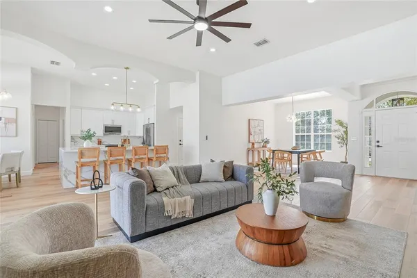 a living room with furniture potted plant and a large window
