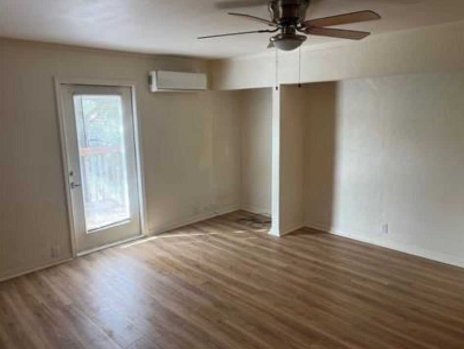230 Six Pines Road San Marcos, TX 78666 - Photo 12 of 21 an empty room with wooden floor cabinet and windows