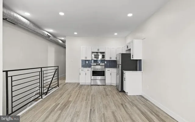 a kitchen with stainless steel appliances a refrigerator and a stove top oven