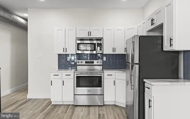 a kitchen with stainless steel appliances a refrigerator stove and microwave