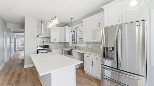 a large kitchen with kitchen island a stove a sink a counter space and a window